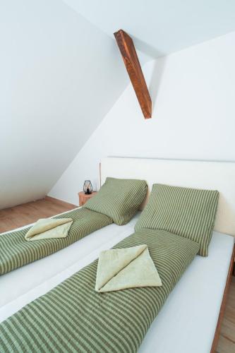two beds with pillows on them in a room at Harmónia Ház in Orfű