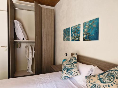 a bedroom with a bed and two paintings on the wall at Balcony Lake View Apartment in Lierna