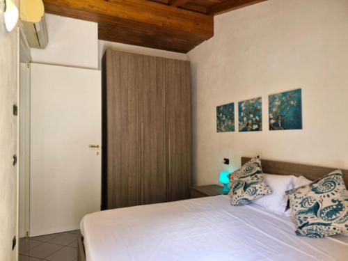 a bedroom with a white bed with blue and white pillows at Balcony Lake View Apartment in Lierna