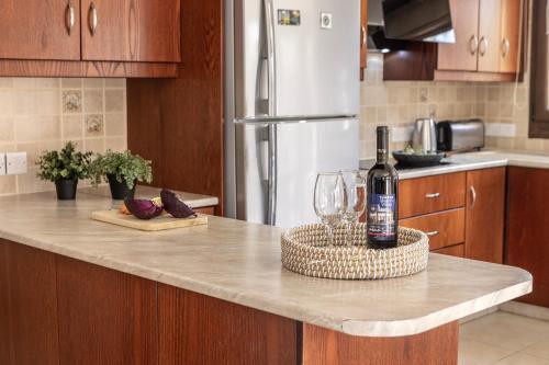 a kitchen with a counter with a bottle of wine and glasses at Villa Tsikkos Dio in Limassol