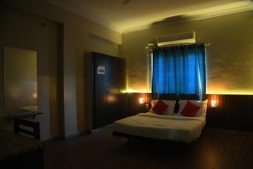 a bedroom with a bed with a blue curtain at Goldhorn Hotels & Banquet Mehdipatnam Near St Ann's college in Hyderabad
