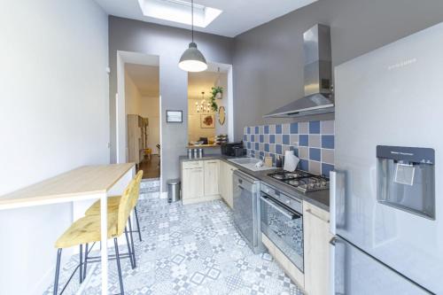 une cuisine avec une table et une cuisinière four supérieur dans l'établissement Le Garden Wifi Jardin Gare, à Laval