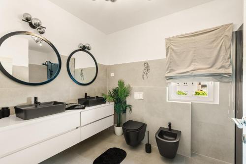 Un baño con dos lavabos y un espejo. en Villa Renči, en Buje