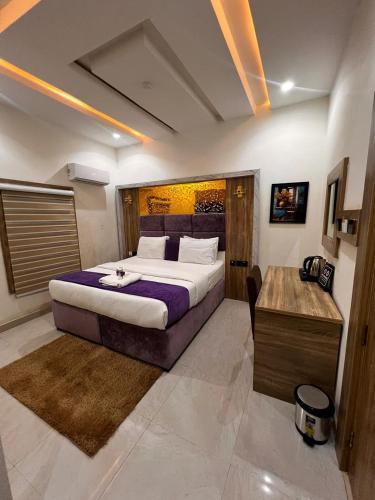 a bedroom with a large bed and a desk at Triple J Universal Hotel and Suites in Asaba