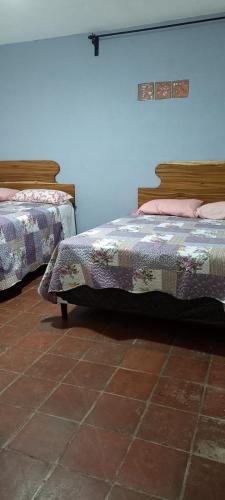a bedroom with two beds and a tile floor at Apartamento The River in Panajachel