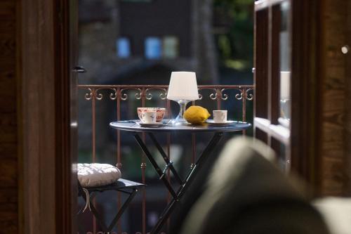 a table with two cups and a lemon on a balcony at Luxury apartment in Valtournenche in Valtournenche