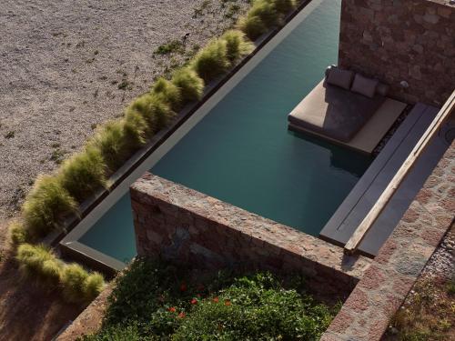 a swimming pool with a bench in the water at D3 Milos in Plaka Milou