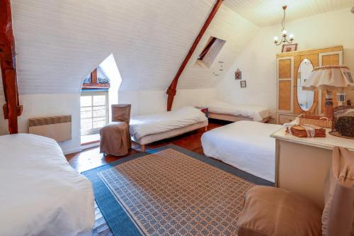 CléguérecにあるGites Les Hibouxのベッド2台とテーブルのある寝室