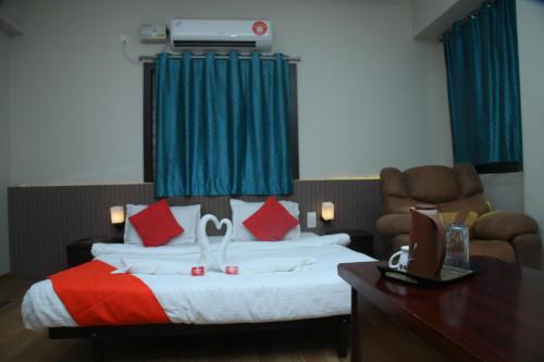 a hotel room with a bed with red and white pillows at Goldhorn Hotels & Banquet Mehdipatnam Near St Ann's college in Hyderabad