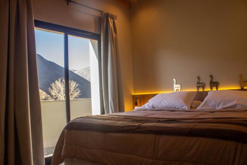 - une chambre avec un lit et une vue sur la montagne dans l'établissement Los Olivos Purmamarca - Cabañas Boutique, à Purmamarca