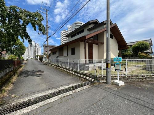 a building on the side of a street with a fence at UMIIE-小松浜-Private STAY in Miyazu