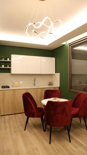 a dining room with a table and two red chairs at BView in Ehden