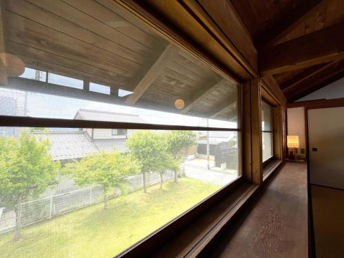 a large window in a room with a view of a yard at UMIIE-小松浜-Private STAY in Miyazu
