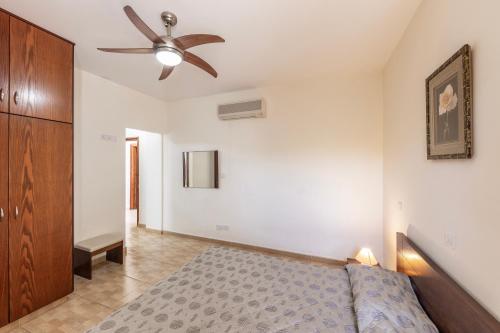 a bedroom with a bed and a ceiling fan at Villa Tsikkos Dio in Limassol