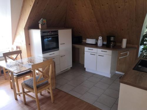 a kitchen with white cabinets and a table with a table sidx sidx sidx at Ruhe und Natur in Seedorf in Demmin