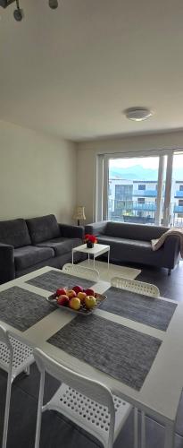 a living room with a couch and a table with fruit on it at Appartement entier 85m2, 2 chambres, 2 salles de bain, salon, cuisine entièrement équipée, au Bouveret in Port-Valais