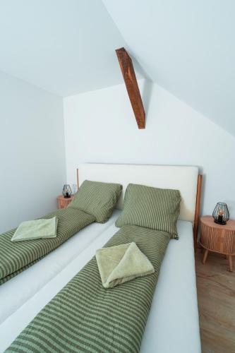 three beds are lined up on a white wall at Harmónia Ház in Orfű