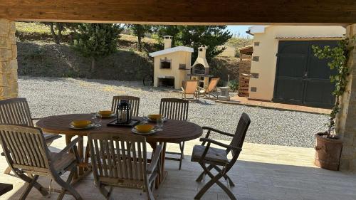 ein Holztisch und Stühle auf einer Terrasse in der Unterkunft Villa La Cava in Riparbella
