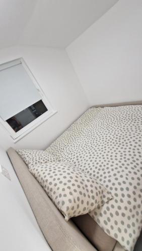 a bed with a pillow and a mirror on it at Hiška Betnava - G115 in Podčetrtek