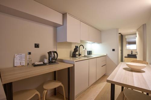 a kitchen with white cabinets and a wooden table at Signature Apartments Santa Catarina in Porto