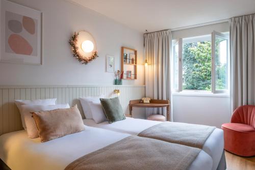 a bedroom with a large white bed and a window at Hôtel Maison Lacassagne Lyon in Lyon
