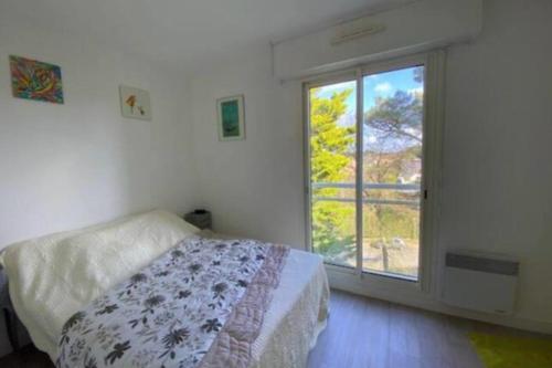 une chambre avec un lit et une grande fenêtre dans l'établissement LE ROYAL - 500m plage - Wifi - Parking, à La Baule