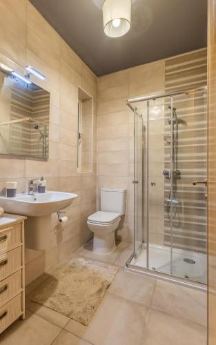 a bathroom with a shower and a toilet and a sink at Modern 3BR w Terrace Near Beaches & Restaurants by QuickTrips in St. Paul's Bay