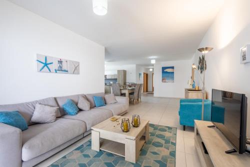 a living room with a couch and a tv at Modern 3BR w Terrace Near Beaches & Restaurants by QuickTrips in St. Paul's Bay