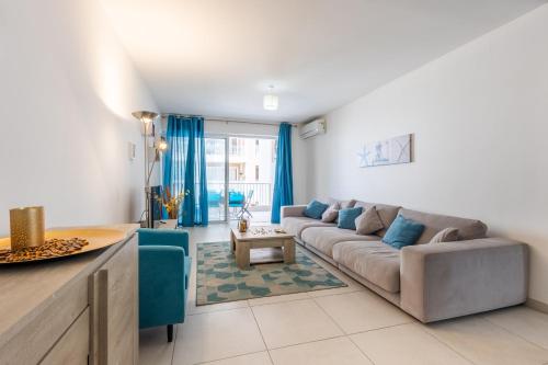 a living room with a couch and a table at Modern 3BR w Terrace Near Beaches & Restaurants by QuickTrips in St. Paul's Bay