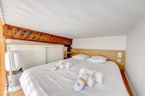 - une chambre avec un lit et 3 paires de chaussons dans l'établissement Le Renaud - Le Marais - Wifi - Balcon, à Paris