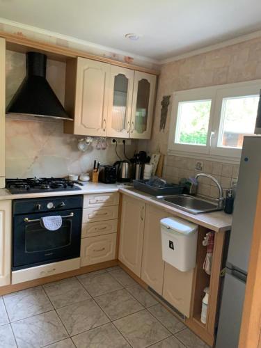 a small kitchen with a stove and a sink at Apartment in a quiet area, near the sea and forest in Jūrmala