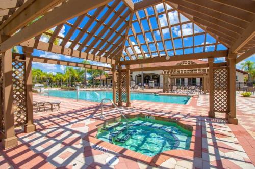ein Außenpool mit einer großen Holzpergola in der Unterkunft Lovely 3BR Villa - Bella Vida Resort - Pool & BBQ! in Kissimmee