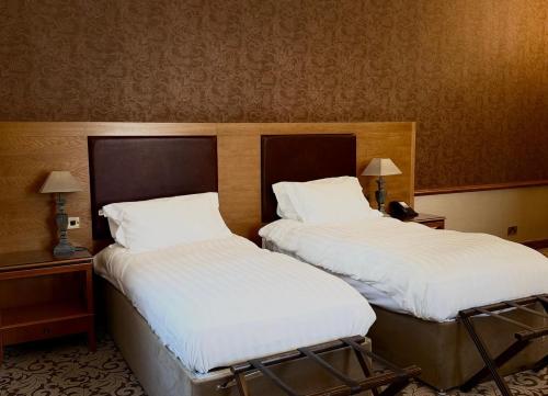 two beds sitting next to each other in a room at Nunsmere Hall Hotel in Oakmere