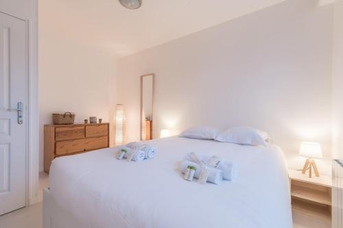 - une chambre dotée d'un lit blanc avec des draps et des oreillers blancs dans l'établissement L'URBAIN - 600m gare - Parking, à Saint-Nazaire