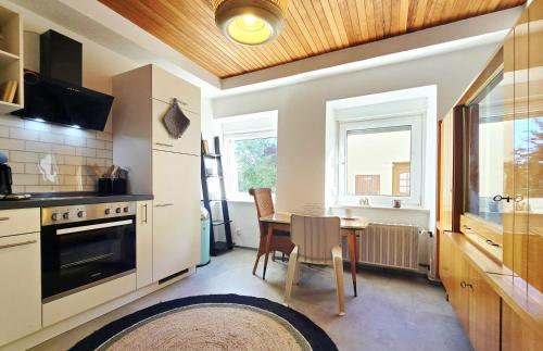 une cuisine avec une table et une salle à manger dans l'établissement 5 Minuten zur historischen Altstadt gemütliche Ferienwohnung in Trier Heilig-Kreuz, à Trèves