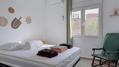 ein Schlafzimmer mit einem Bett und einem grünen Stuhl in der Unterkunft Charmante maison familiale 90 m avec patio 8 couchages in Moratalla