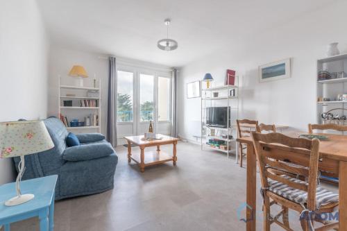 Una sala de estar con un sofá azul y una mesa. en L'Amiral -500m Plage des Carrés- Parking, en La Bernerie-en-Retz