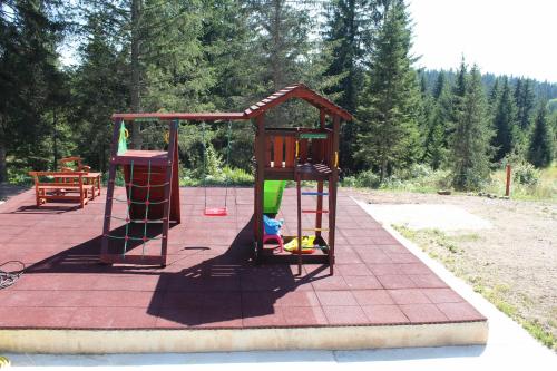 a playground with a play set on a red tile at Chechar Inn Zlatar in Nova Varoš