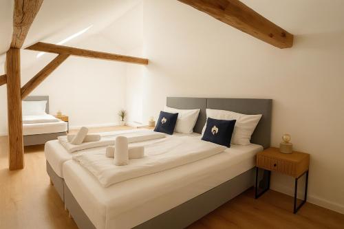 a bedroom with a large white bed with blue pillows at SMS-Homes I Auszeit am See #2 in Waltenhofen