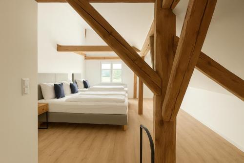 a bedroom with white walls and wooden beams at SMS-Homes I Auszeit am See #1 in Waltenhofen