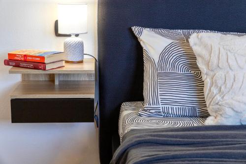 a bed with a pillow and a side table with a lamp at SARDINIA RE - Attico Monte Oro in Sassari