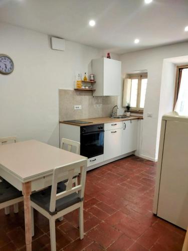 a kitchen with white cabinets and a table in it at The Voltina in Diecimo