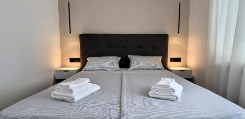 a bedroom with a bed with towels on it at Apartman Renata in Županja