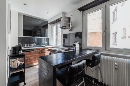 une cuisine avec un comptoir noir dans une pièce dans l'établissement Studio Or - Studio à la Krutenau, à Strasbourg