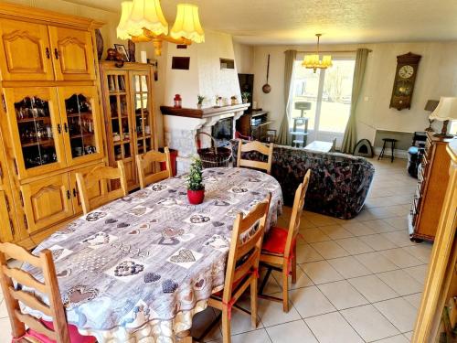 a dining room with a table and chairs and a fireplace at Cozy 2 bedroom house in Sars-Poteries