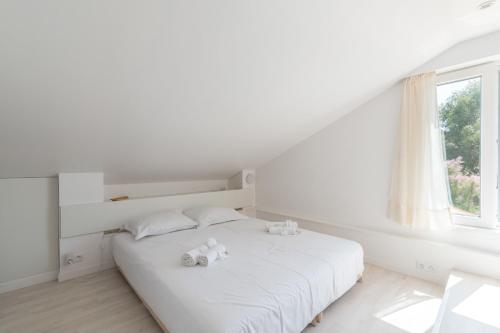 - une chambre blanche dotée d'un lit avec deux ours en peluche dans l'établissement La P'tite Prée - Wifi - Parking, à Préfailles