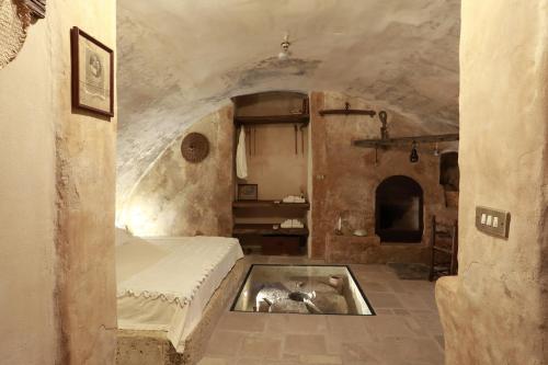 a bedroom with a bed and a tub in the floor at Casa Nachiro - 16th Century Oil Mill Historic Dimora in Nardò