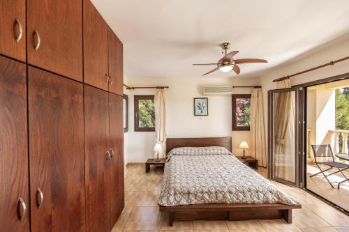a bedroom with a bed and a ceiling fan at Villa Tsikkos Pende in Argaka
