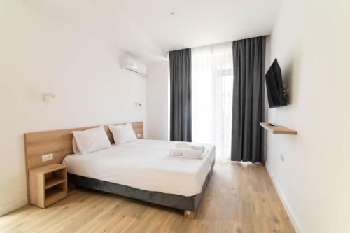 a bedroom with a bed and a large window at Rosiem Boutique in Techirghiol