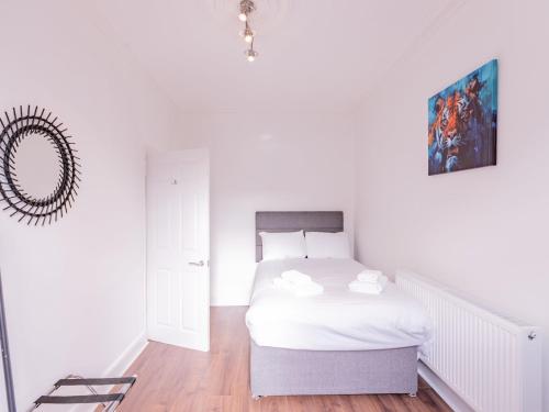 ウェストクリフ・オン・シーにあるPass the Keys Comfortable Flat with Patio Sleeps 4のベッドと鏡のある白い寝室